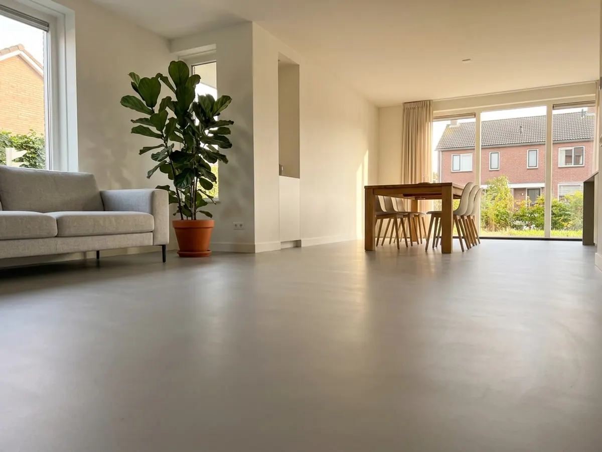 Moderne lichte Nederlandse woonkamer met strakke gietvloer en vloerverwarming zonder radiatoren